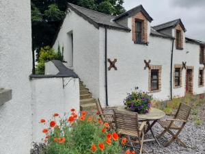 Casa blanca con mesa, sillas y flores en Moira Barn At Berwickhall, en Moira