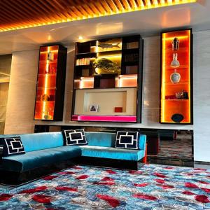 een woonkamer met een blauwe bank en een tapijt bij THE FACE Style in Kuala Lumpur