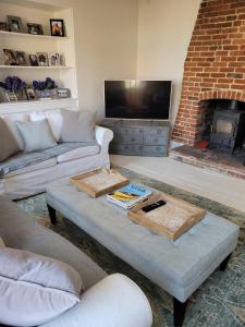 a living room with a couch and a fireplace at A Unique Cottage in the centre of Cley in Cley next the Sea