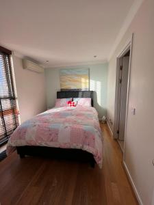 a bedroom with a bed with a pink comforter at Beautiful centrally located spacious Penthouse flat. in London