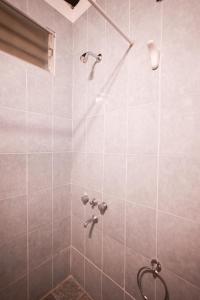 y baño con ducha de azulejos grises. en Monoambiente familiar en San Rafael para 4 personas en barrio céntrico en San Rafael