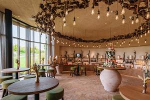 普埃尼亞戈的住宿－Conti Thun Wine Resort，一间设有桌椅的餐厅,位于带窗户的房间内