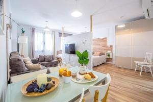una cocina y una sala de estar con una mesa con comida. en CARTAGENAFLATS, Apartamentos Anfiteatro Romano 5B, en Cartagena