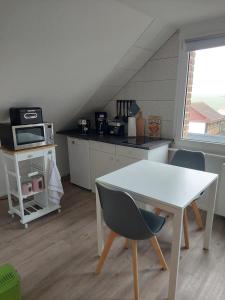 a kitchen with a white table and a microwave at Pension Limone Ferienwohnung 2 in Neu Lindenberg