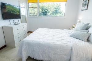 1 dormitorio blanco con 1 cama y TV de pantalla plana en Estancia Anastasia en La Orotava