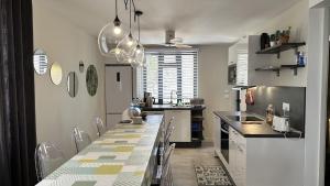 una cucina con un lungo tavolo e sedie di Les Cerisiers - Beach Apartment with Pool, Few Steps to the Beach a Flic-en-Flac