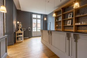 a large room with a counter and shelves at La Maison Blanche - AppartHôtels de charme Chic & Cosy à 350m du cœur de ville de Limoges - Accès autonome in Limoges