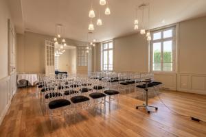 a room with tables and chairs in a room with windows at La Maison Blanche - AppartHôtels de charme Chic & Cosy à 350m du cœur de ville de Limoges - Accès autonome in Limoges +22 photos