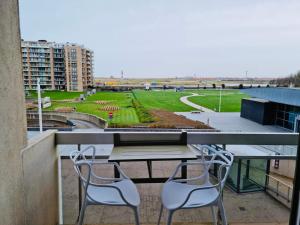 a table and two chairs on a balcony with a view at Appartement 't Pand in Nieuwpoort