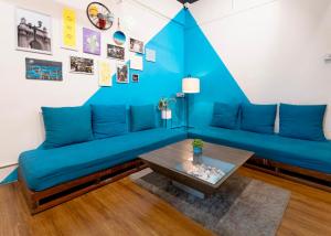 a living room with a blue couch and a table at Locomo Mumbai - Stay Work Eat in Mumbai