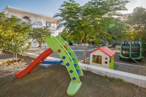 un parque infantil con tobogán y una casa de juegos en Salora Studio-Apartments, en Archangelos