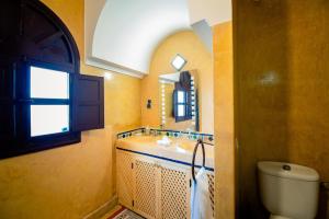 a bathroom with a sink and a toilet and a mirror at ArtHouse Cinema Hotel in Essaouira