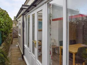 une porte coulissante en verre menant à une terrasse avec une table. dans l'établissement Lyndhurst Apartment, à Sandown