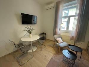 un soggiorno con tavolo, sedie e TV di At Home - City Center Zagreb a Zagabria