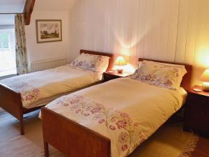 two twin beds in a room with two lamps at The Old Post Office in Yellowham Wood