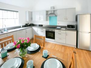 a kitchen with a dining table and a refrigerator at Rossie Cottage in Auchterarder