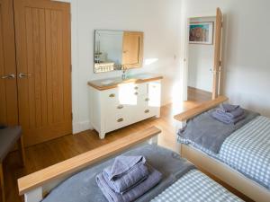 a room with two beds and a sink and a mirror at Rossie Cottage in Auchterarder