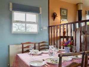 a dining room table with a pink tablecloth on it at Bugatti House in Bosbury