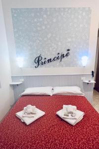a bed with two white towels on top of it at Hotel Principe in Pietra Ligure