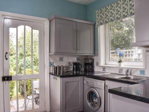 a kitchen with a sink and a washing machine at Glenesk in Snitter