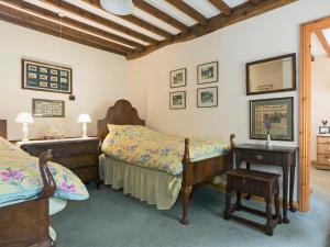 Daglingworth的住宿－Flowers Barn，一间卧室配有两张床和镜子