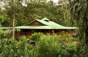 a green and white house with trees at Selva Verde Lodge in Sarapiquí