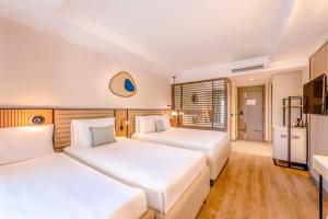 1 dormitorio con 2 camas y TV en Belek Beach Resort Hotel, en Belek