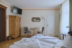1 dormitorio con 2 camas, mesa y sillas en Jahrhunderthotel Leipzig, en Leipzig