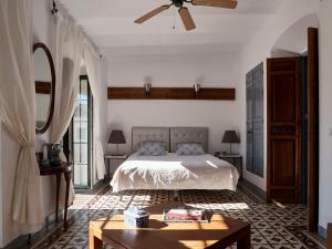 a bedroom with a bed and a ceiling fan at Mesón La Hospedería in Cómpeta