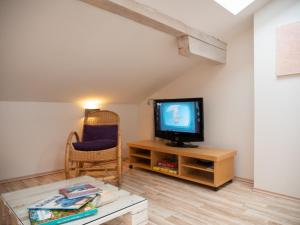 uma sala de estar com uma televisão e uma mesa em Dolomitenloft em Strassen