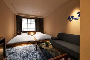 a hotel room with a bed and a couch at Minn Kanazawa in Kanazawa