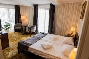 um quarto de hotel com uma cama grande e uma secretária em Hotel Brilliant Plaza em Zalău