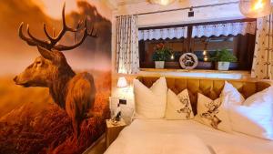 ein Schlafzimmer mit einem Gemälde eines Hirsches an der Wand in der Unterkunft Ferienappartements "Landromantik" in Bautzen