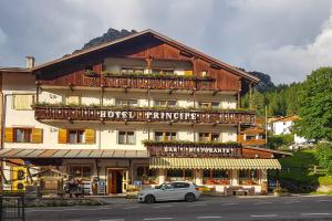 Un coche blanco aparcado delante de un edificio en Hotel Principe, en Selva di Cadore