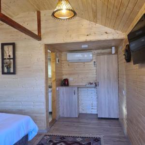 a room with a bed and a kitchen in a cabin at Baltina Parc Transfagarasan in Curtea de Argeş