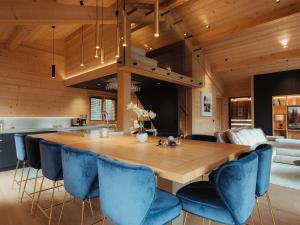 a dining room with a wooden table and blue chairs at Chalet La Clusaz, 7 pièces, 10 personnes - FR-1-304-282 in La Clusaz