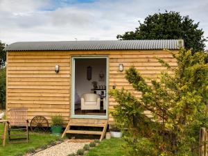 ein kleines Haus in einem Garten mit einer Terrasse in der Unterkunft Rosemary in Wootton Bridge