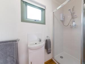 a white bathroom with a sink and a shower at Rosemary in Wootton Bridge