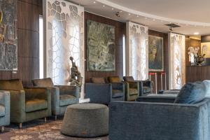 a waiting room with couches and chairs and a table at Hotel Isola Sacra Rome Airport in Fiumicino
