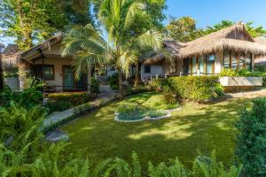 una casa con jardín y palmeras en The Beach Natural Resort Koh Kood, en Ko Kood