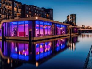 漢堡的住宿－漢堡城美居酒店，水面上灯亮蓝色紫色的建筑