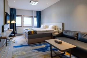 ein Hotelzimmer mit einem Bett und einem Sofa in der Unterkunft Livington Hotel in Stockholm