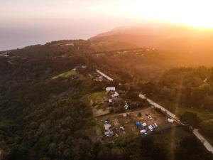 an aerial view of a house on a hill with the sunset at Map Of Africa Ocean View Tiny House in Wilderness