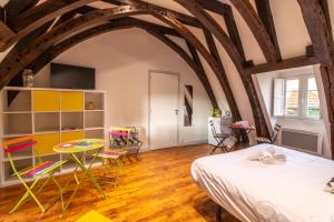 - une chambre avec un lit, une table et des chaises dans l'établissement Les Chambres du "Coup de Coeur de Sarlat", à Sarlat-la-Canéda