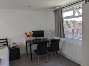 a bedroom with a desk with two chairs and a computer at 32 in Ashford