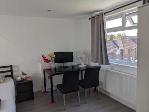 een slaapkamer met een bureau met 2 stoelen en een computer bij 32 in Ashford