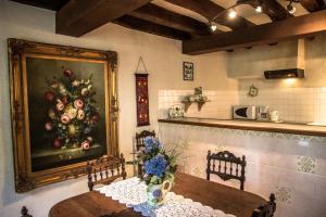 a dining room with a painting of flowers on the wall at Manoir du Mur in Comblessac
