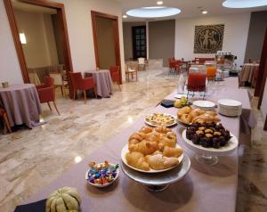 Best Western Park Hotel في بياتشينزا: طاولة طويلة عليها عدة أطباق من الطعام