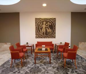 a waiting room with red chairs and a painting on the wall at Best Western Park Hotel in Piacenza