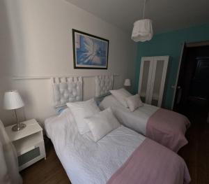 ein Schlafzimmer mit 2 Betten und einem Tisch mit einer Lampe in der Unterkunft VIEUX LOGIS in Vervins